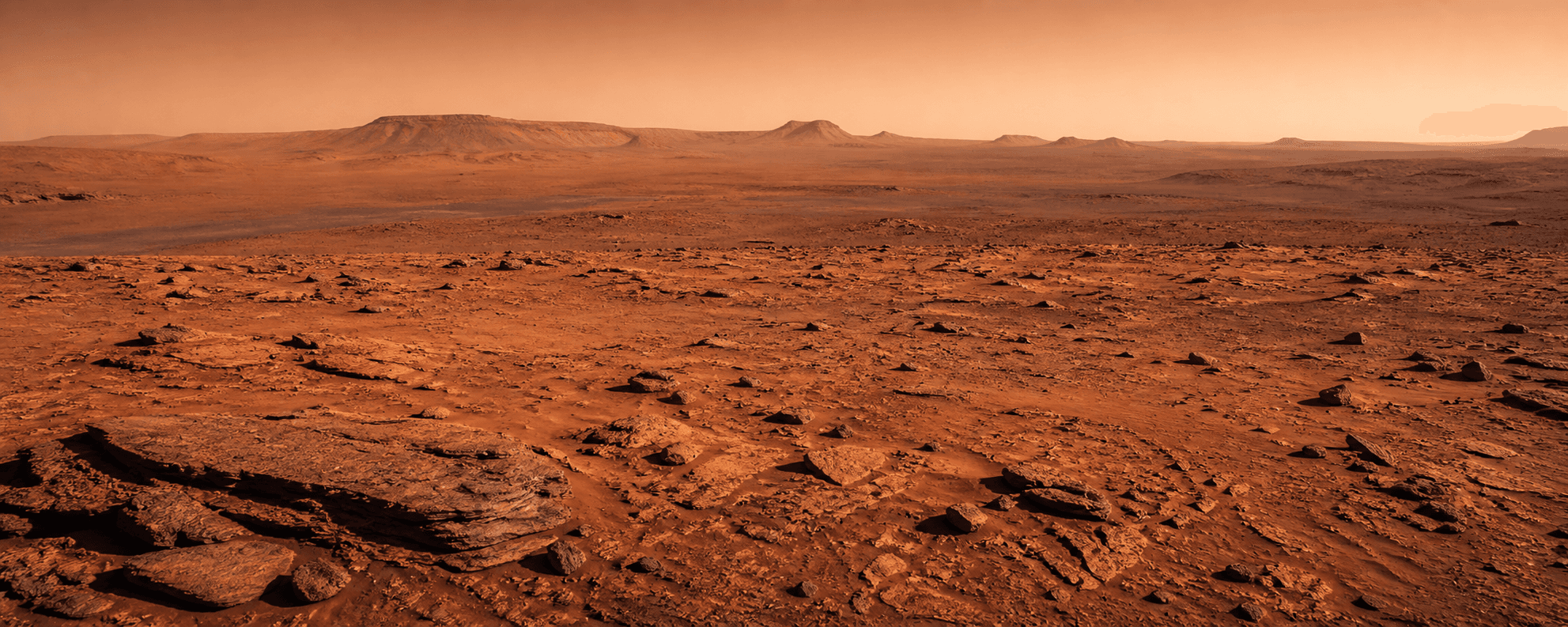 A wide Martian landscape with rust-red rock and distant mesas